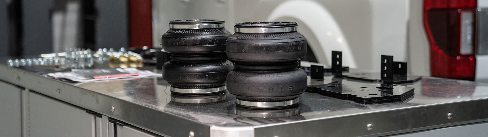 Two air springs with parts and pieces on a table